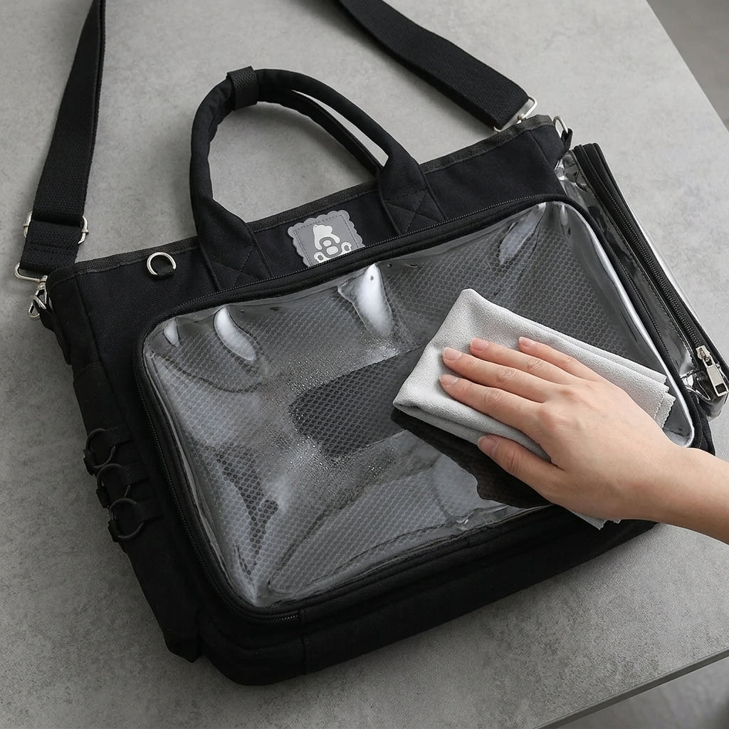 Gentle microfiber cleaning of a black ita bag clear display window on a stable tabletop